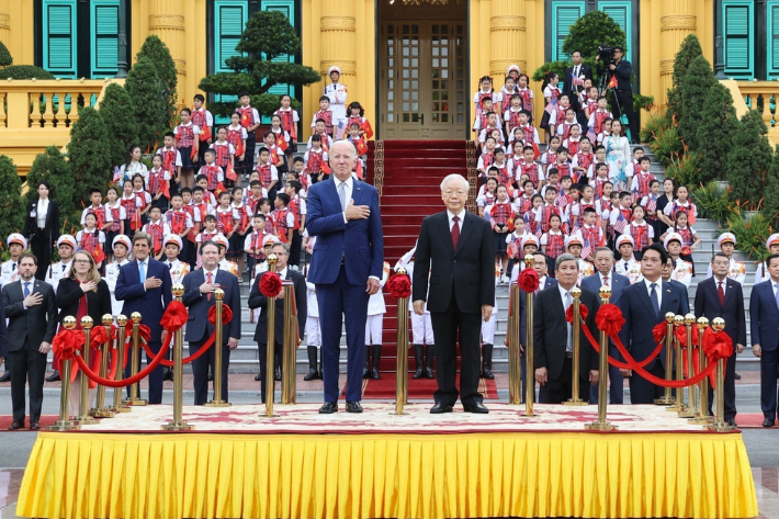 US President Joe Biden (left) gestures as the national anthem of the United States is played during his welcome ceremony, next to the general secretary of the Communist Party of Vietnam, Nguyen Phu Trong, at the Presidential Palace in Hanoi, Vietnam