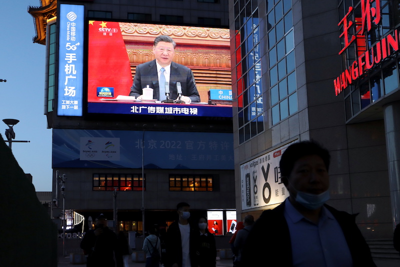 Giant screen shows news footage of Chinese President Xi Jinping attending a video summit on climate change, in Beijing
