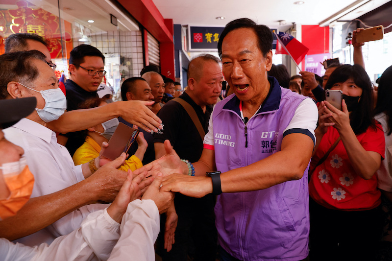 Foxconn founder Terry Gou shakes hands with supporters at one of his signature campaign offices in New Taipei City