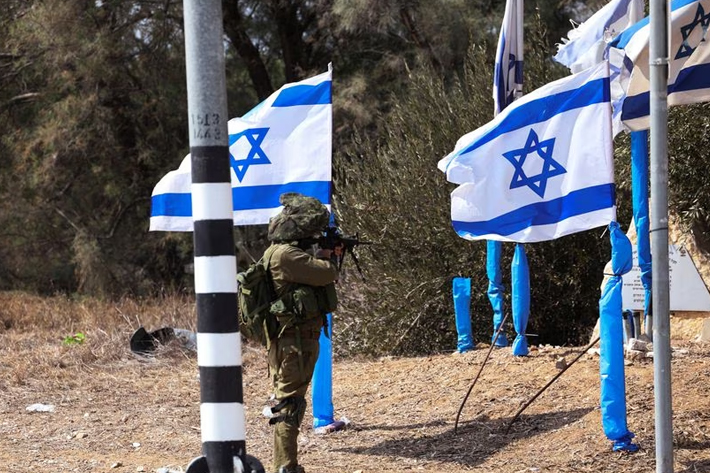 An Israeli soldier stands in position at the entrance to Kibbutz Kfar Aza, in southern Israel