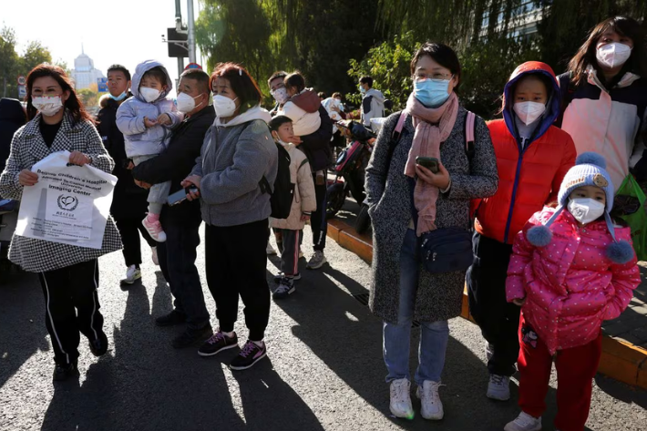 People wait for their rides outside a children's hospital in Beijing, China