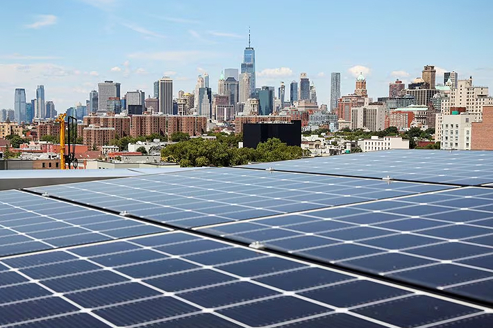 Solar panels are seen along with a view of the neighborhood and lower Manhattan, New York, US