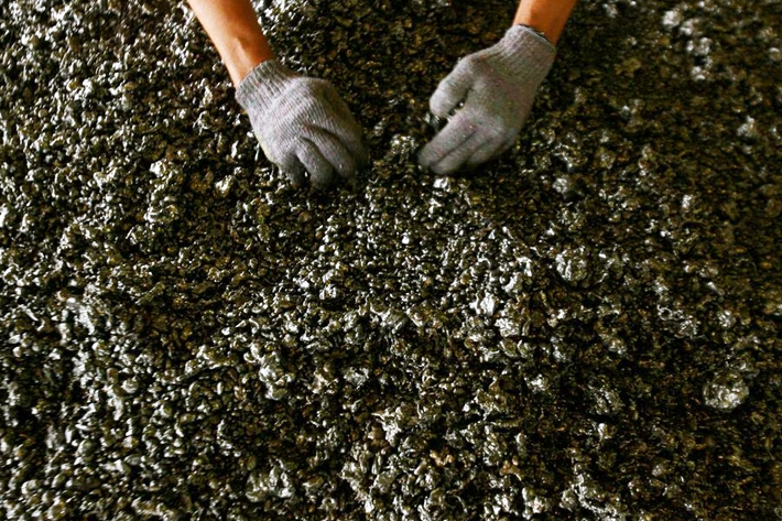 A worker displays nickel ore in a ferronickel smelter owned by state miner Aneka Tambang Tbk at Pomala district, Indonesia