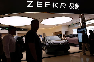 People walk past a booth of Zeekr, Chinese automaker Geely's premium electric vehicle (EV) brand, at a shopping mall in Beijing, China November 3, 2023. REUTERS/Tingshu Wang/File Photo Acquire Licensing Rights