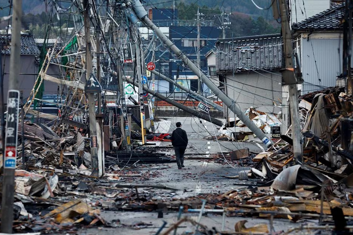 A man makes his way along Asaichi-dori street, which burned down due to a fire following an earthquake, in Wajima, Japan
