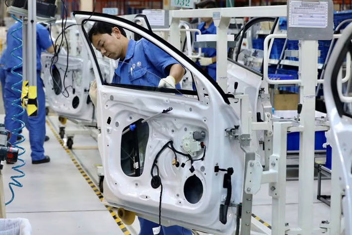 Employees work on assembling vehicles at a plant of SAIC Volkswagen in Urumqi, Xinjiang