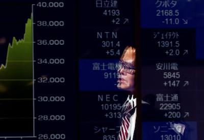 A passerby is reflected on an electronic screen displaying a graph showing recent Japan's Nikkei share average movements and stock prices as the share average hits a record high in Tokyo, Japan February 26, 2024. REUTERS/Issei Kato/File Photo Purchase Licensing Rights