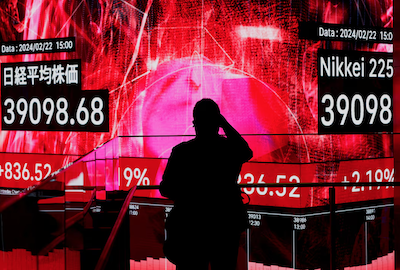 A visitor using his smartphone takes photos of an electronic screen displaying Japan's Nikkei share average, which surged past an all-time record high scaled in December 1989, inside a building in Tokyo, Japan February 22, 2024. REUTERS/Issei Kato/File Photo Purchase Licensing Rights