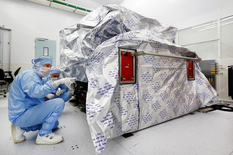 ASML assembly engineers work on a Twinscan DUV lithography system at their base in Veldhoven