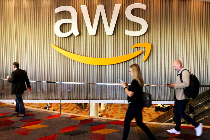 Attendees at Amazon.com Inc annual cloud computing conference walk past the Amazon Web Services logo in Las Vegas, Nevada, US